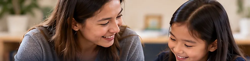A teacher smiling as she guides a young student